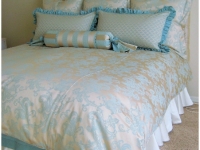 Deep tufted headboard duvet with euro shams and bolster by Drapery Solutions.