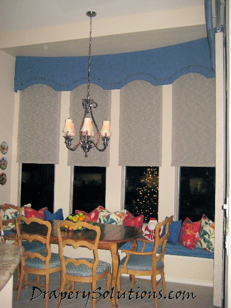 Bowed cornice with motorized solar shades by Drapery Solutions.