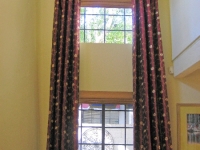 Two story window drapery with gathered tabs and ruched sleeve by Drapery Solutions.