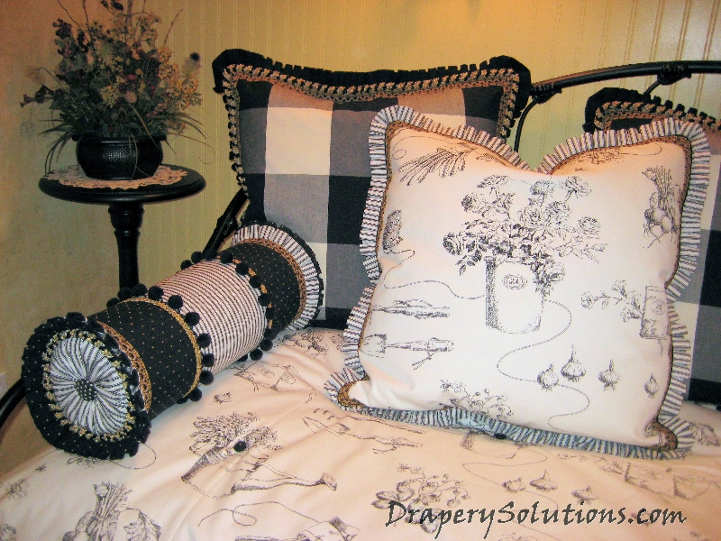 Pillows and bolster with box pleated ruffles by Drapery Solutions.