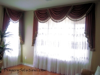 Classic center swag and cascade valance over sheer panels by Drapery Solutions.